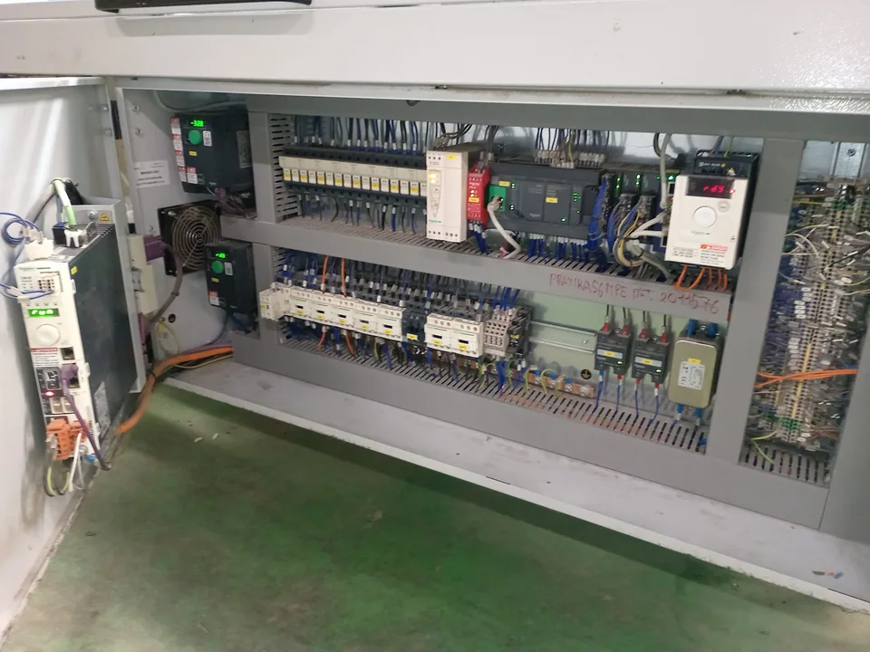 Quadro elettrico aperto di una confezionatrice, con interruttori, morsettiere e azionamenti su due ripiani
