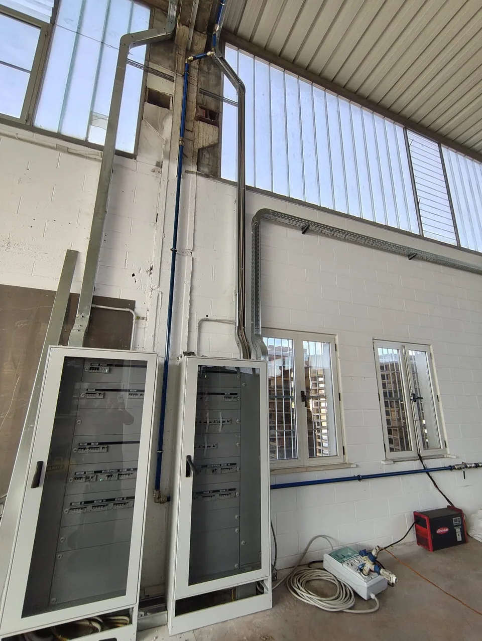 Electrical panels being installed, with the air line branching off along the column