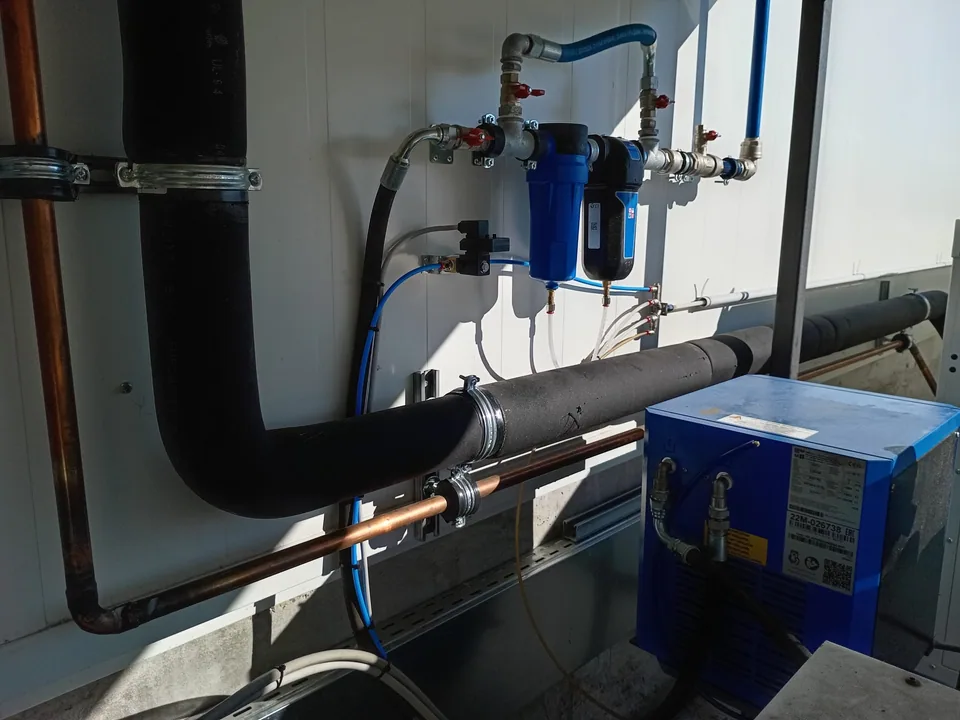 Connections between compressor, filters and dryer along the room wall