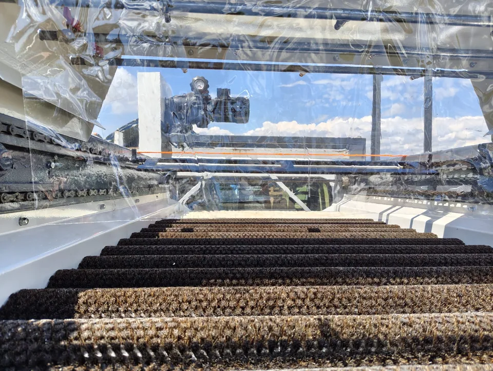 Brush rollers of the machine running, seen end-on through the clear guard