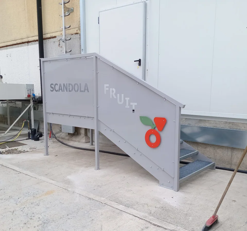Scala di emergenza in acciaio verniciato addossata alla parete dello stabilimento, con gradini grigliati