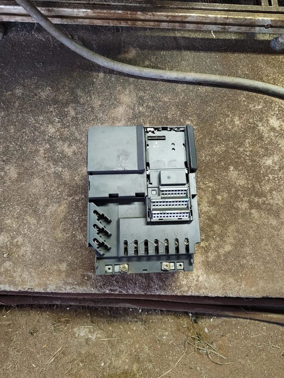The old inverter on the floor, with the power terminals visible